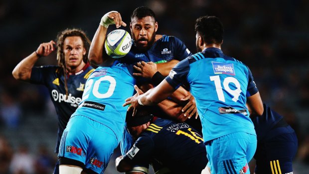 Patrick Tuipulotu of the Blues looks to offload the ball as he is tackled.