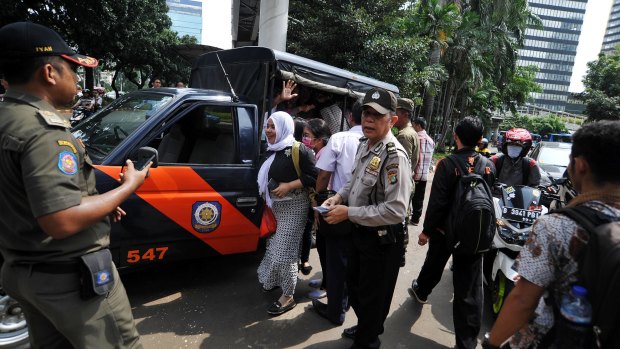Citizens evacuated by police during the mass  unrest over public transport in Jakarta.