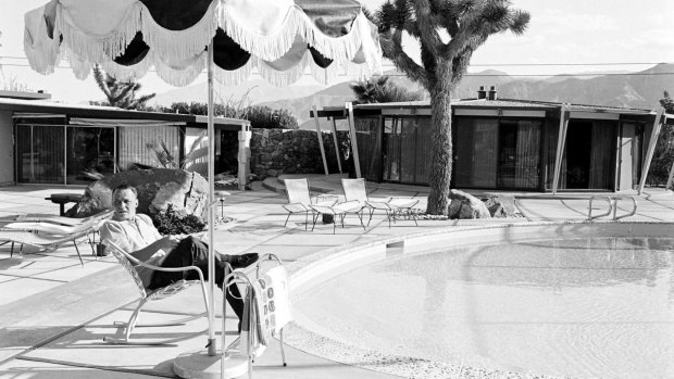 American entertainer Frank Sinatra sits in a deck chair beside the pool at his home and reads a script (for his film 'Marriage on the Rocks'), Palm Springs, California, 1965. 