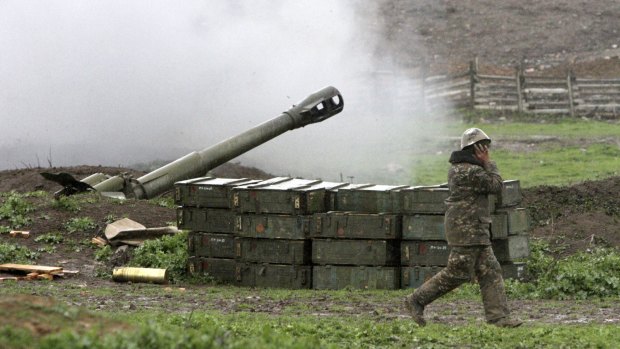 An Armenian covers his ears while a howitzer fires at an artillery position of the self-defence army of Nagorno-Karabakh near Martakert, Azerbaijan, on Sunday. 