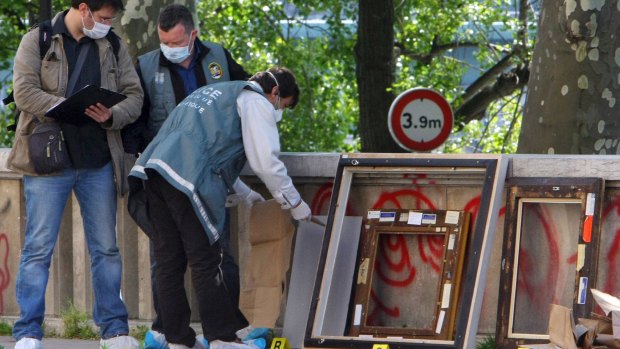 Police officers search for clues as they pack up the frames of the stolen paintings outside the Paris Museum of Modern Art, in 2010. 