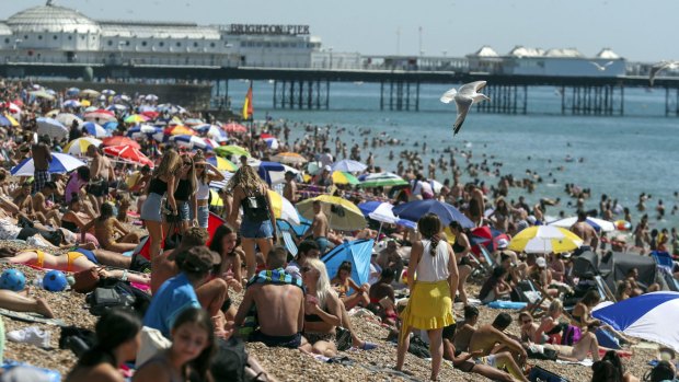 People crowd Brighton Beach in England this northern summer, showing scant regard for social distancing rules.