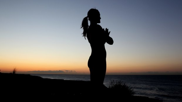 Popular as fitness around the world: A woman enjoys some early-morning yoga at Coogee Beach.