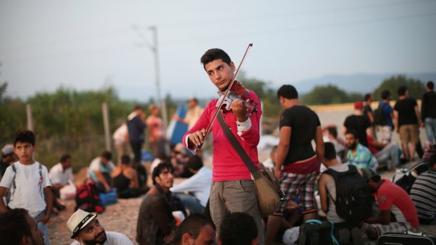 Syrian Rami Basisah plays for his fellow refugees at the Greece-Macedonia border in 2015.