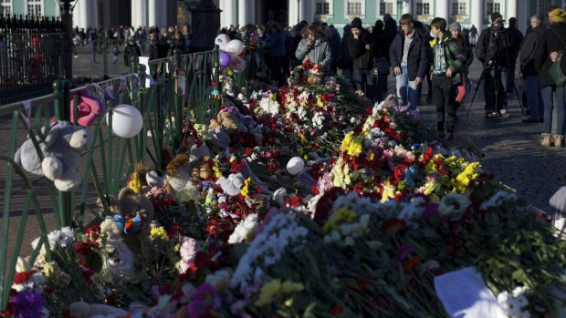 People gathered to lay flowers in memory of the plane crash victims at Dvortsovaya Square in St Petersburg on Thursday. 