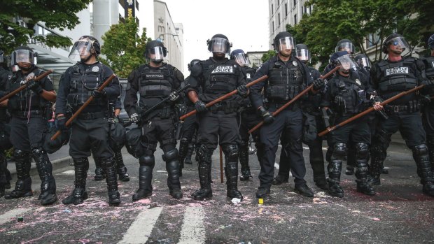Police stand during a rally in Seattle on Sunday when protesters decrying hatred and racism converged around the country.