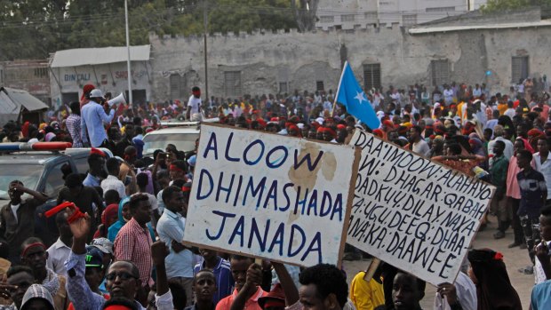 Protesters march on Wednesday with placards reading "Out al- Shabab", left, and "Oh God, have mercy on the dead" near the scene of Saturday's massive truck bombing in Mogadishu.