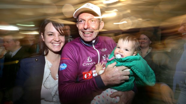 Sore but relieved: After crossing the finish line, Tony Abbott is greeted by Rebecca Goldfinch, wife of a local councillor, and her baby Dakota.