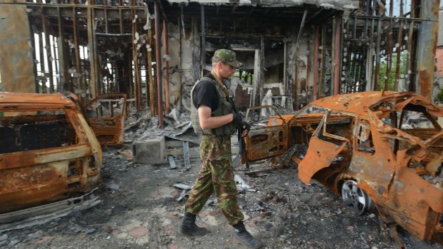 A Ukrainian soldier on Thursday walks past a destroyed house on the frontline facing pro-Russian separatists near Donetsk in eastern Ukraine.