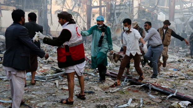 Medics carry the body of a victim of a Saudi-led coalition airstrike in Sanaa, Yemen.
