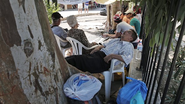 A registered migrant sleeps surrounded by members of his family in the grounds of the headquarters of the local coast guard on the island of Leros, Greece.