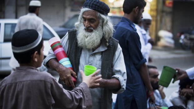 A Pakistani volunteer provides cups for cold water or milk provided during the fasting month of Ramadan in Rawalpindi on Wednesday.