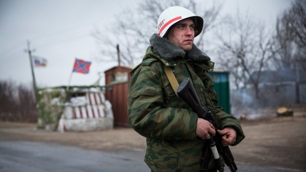 A pro-Russian separatist stands guard at a check point  on the road to Mariupol in March. 