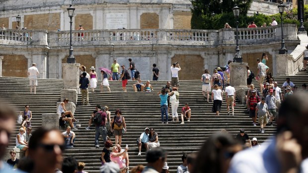 Pedestrians walk past the Spanish Steps in Rome, Italy. The city is hoping people will sponsor the restoration of famous monuments.