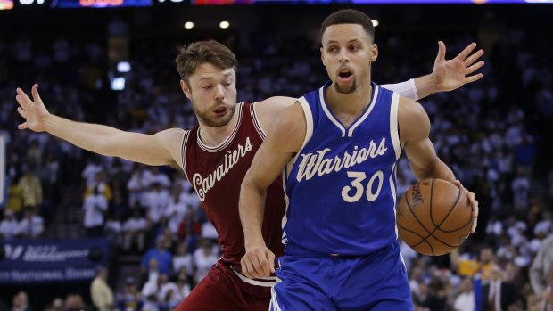 Golden State Warriors' Stephen Curry (right) dribbles past Cleveland Cavaliers' Matthew Dellavedova.