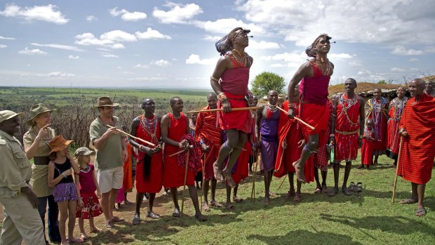 A family watches a group of Maasai warriors in Kenya.