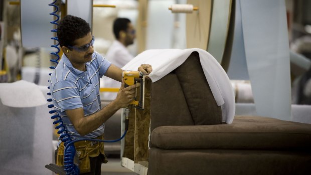 An immigrant employee at a furniture factory in Manitoba, Canada.