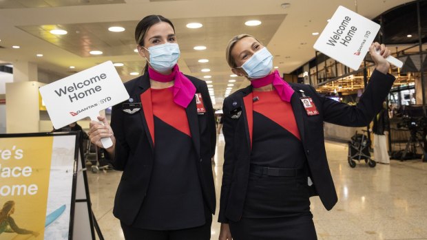 Qantas staff welcome people arriving at Sydney International Airport on Monday morning.