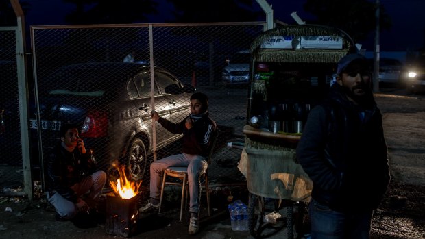 Street vendors keep warm by a fire at the closed Turkish border gate in Kilis on Tuesday.