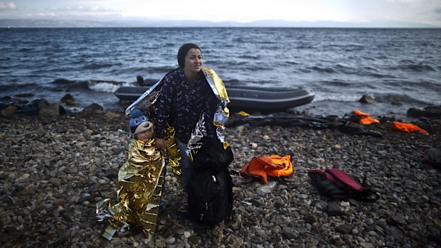 A Syrian refugee woman and child arrive on a dinghy on the Greek island of Lesbos on Friday.