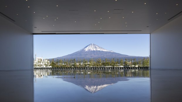 At the top, after "sunrise from the summit" views, the ramp reaches its own destination: a white, gallery-like space. There's no art on the walls, just a wide doorway opening onto a broad patio and framing the star of the show: Mount Fuji herself.