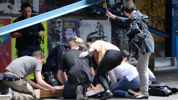 Witnesses help the injured on Bourke Street.