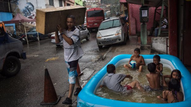 Children play in a swimming pool at the 23 de Enero neighborhood in Caracas, Venezuela.