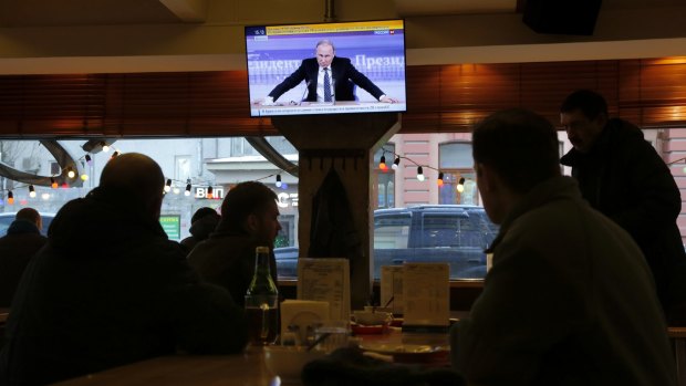 Russians watch a televised question-and-answer session with President Vladimir Putin in Moscow on Thursday. 