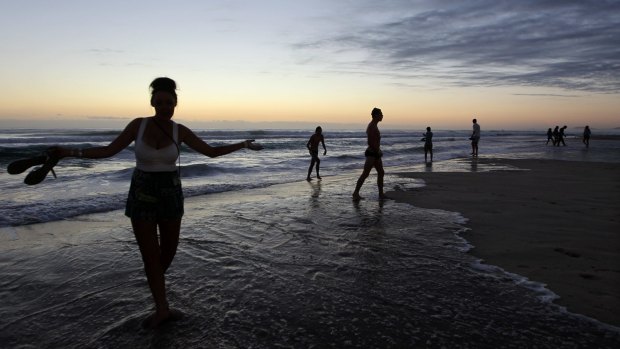 Schoolies wait for the sun to rise on the beach at Surfers Paradise.