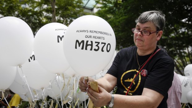 Jacquita Gomes, wife of Patrick Gomes, the in-flight supervisor on the ill fated Malaysia Airlines Flight 370, prepares balloons with names of those on board during a remembrance event in Kuala Lumpur on Sunday.