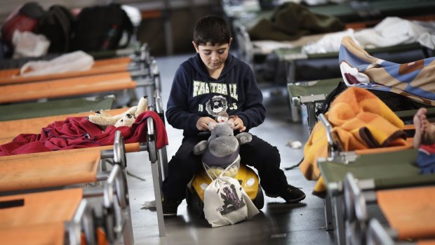 A boy plays as he waits with other refugees for registration at the temporary registration centre of the south German border town Passau.