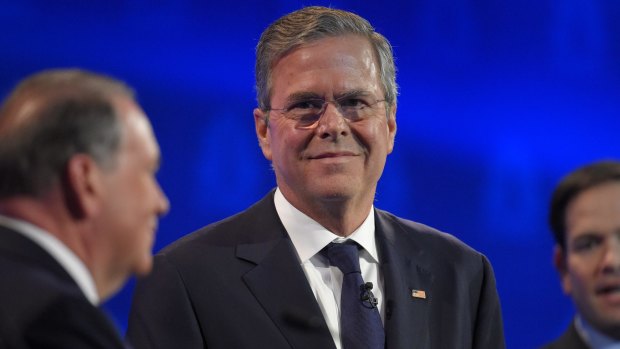 Jeb Bush, centre, stands with Mike Huckabee, left, and Marco Rubio, right, during the debate. 