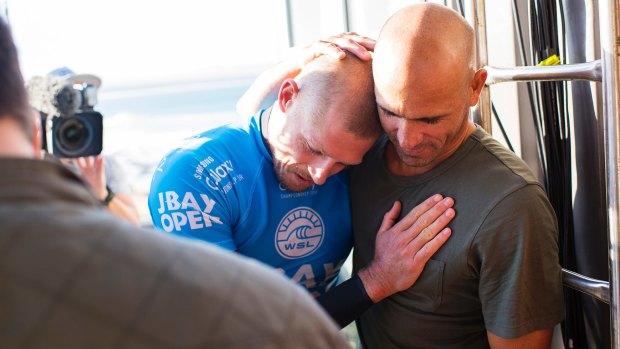 Mick Fanning and Kelly Slater hug after Fanning was attacked by a shark.