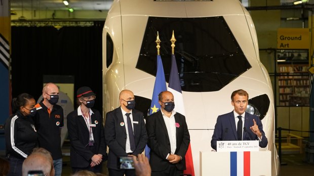 French President Emmanuel Macron (R) speaks at the TGV's unveiling.
