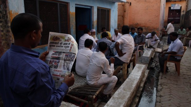 A relative of Mohammad Akhlaq reads a newspaper carrying news of Akhlaq's killing.