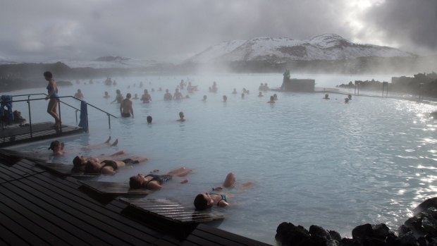Guests relax in geothermal seawater in the main lagoon at the Blue Lagoon spa in Grindavik, Iceland, 