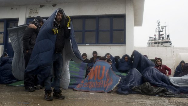 Refugees and migrants wait at the port of the island of Oinousses to be transferred to  the Greek island of Chios, near Lesbos on Wednesday.