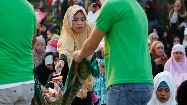 Filipino Muslims donate cash for tens of thousands of Muslims displaced in the siege of Marawi at Eid prayers in Manila's Rizal Park on June 25.