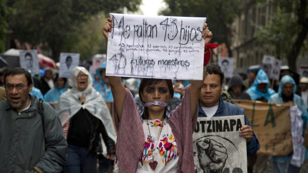 "I'm missing 43 children. 43 future teachers": A woman holds up a sign in a September 2015 march in Mexico City.