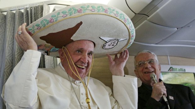 Pope Francis wears a traditional Mexican sombrero hat he received as a gift from a Mexican journalist during the flight from Rome to Havana.