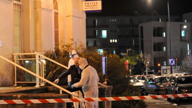 French police collect evidence outside the police station at Joue-les-Tours, where officers shot a man who attacked them with a knife.