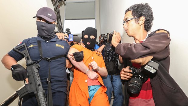 Australian man Isaac Emmanuel Roberts is escorted by officers at the customs office in Bali.