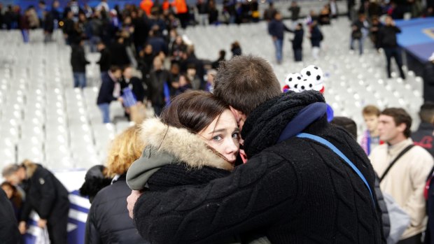 A supporter comforts a friend at the Stade de France.