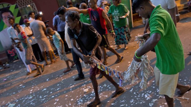Supporters of Sri Lanka's ruling party lay fire crackers on a road as they celebrating the party's election performance in Colombo.