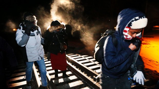 Eight migrants from Somalia cross into Canada illegally from the US on February 26, walking down a train track into the town of Emerson, Manitoba.