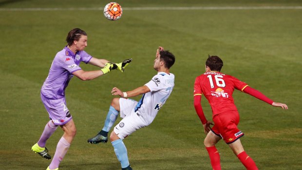 Adelaide United goalkeeper John Hall attempts to block Bruno Fornaroli of Melbourne City.