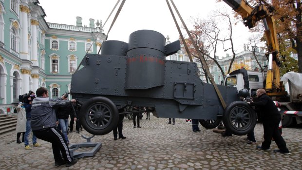 Workers install an armoured car with the Bolshevik slogan 'Vrag Kapital' (The Enemy of Capital), similar to the one Lenin used to address the crowd during  1917, in the yard of the Winter Palace in St Petersburg earlier this month.