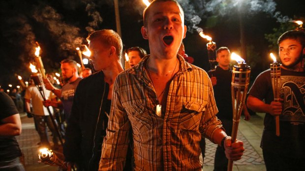 White nationalist groups march with torches through a univeristy campus in Charlottesville.