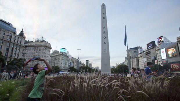 Children play near the Buenos Aires Obelisk covered with the Spanish words: "40 years" in reference to the 40th anniversary of the military coup.