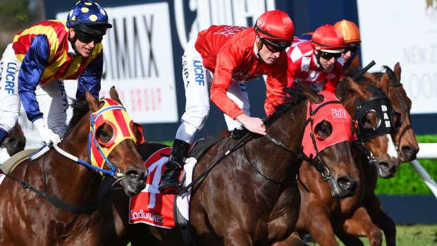 Mark Zahra, centre, riding Redzel defeats Nicholas Hall, left, riding Under the Louvre in race 5 of the Resimax Stakes at Caulfield Racecourse on Saturday, August 27.